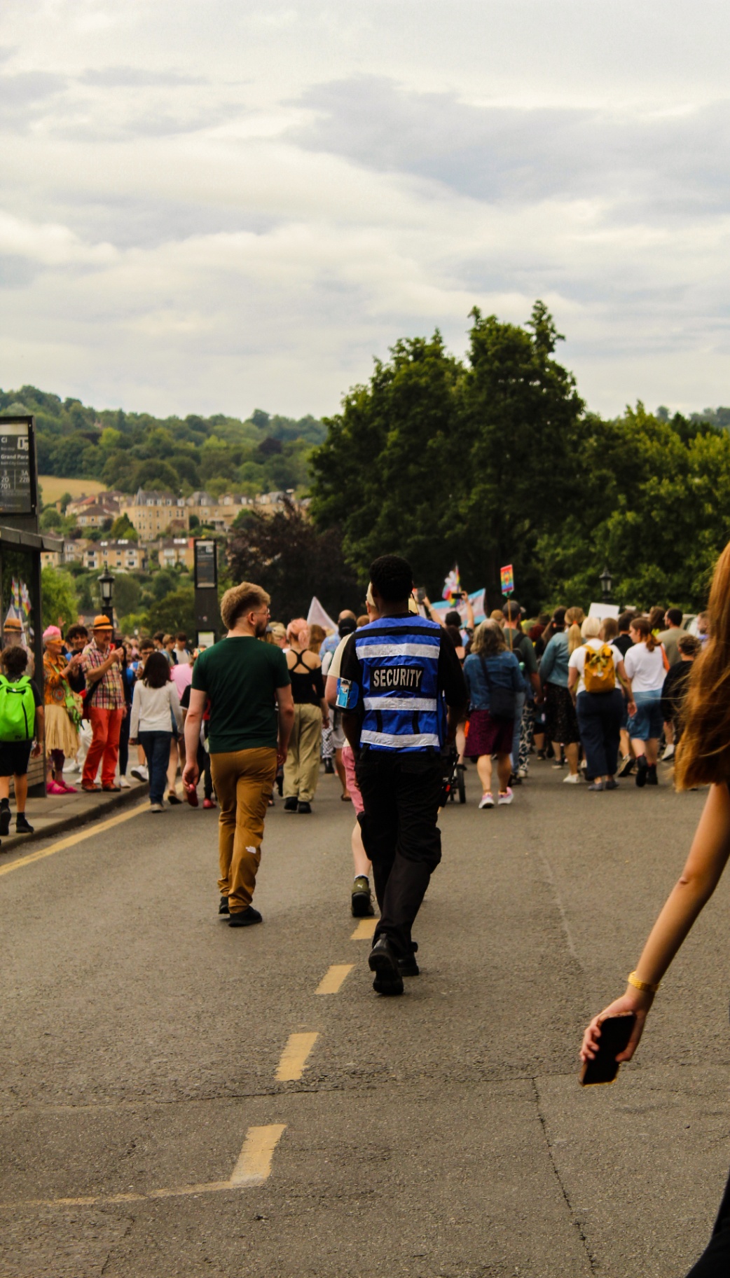 Event security officer supporting festival-goers under a Bath welcome tent