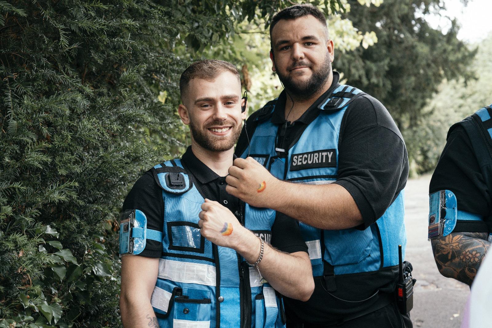 Two AV Group UK security officers with rainbow face paint at Bath Pride