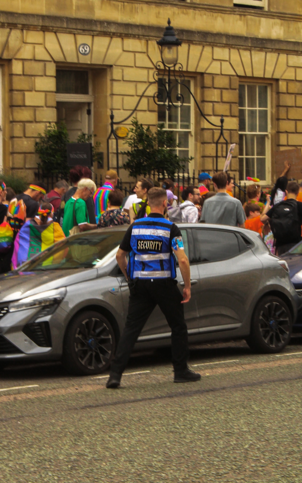 Uniformed security officer overseeing a busy Bath market crowd